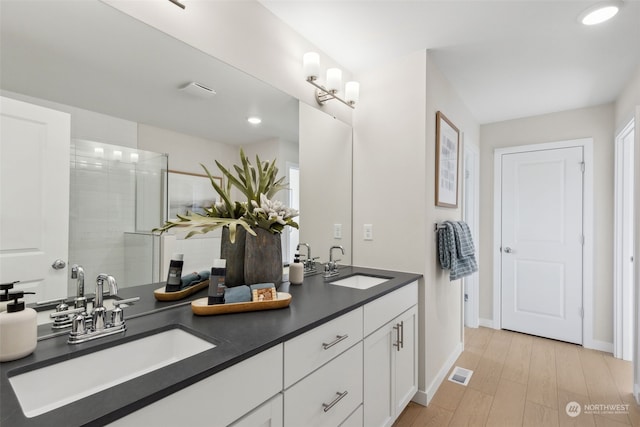 bathroom featuring vanity, a shower with shower door, and hardwood / wood-style flooring