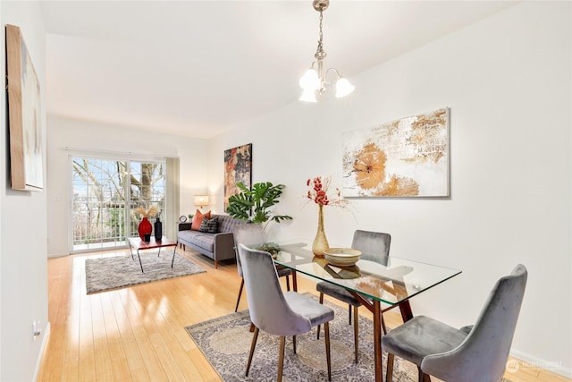 dining space featuring wood-type flooring and a chandelier