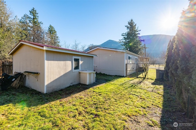 view of side of home with a mountain view and a yard