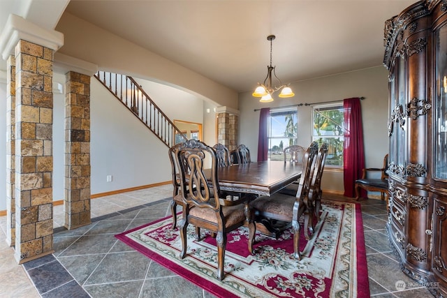 dining area with decorative columns and a chandelier