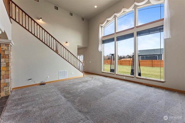 unfurnished living room with a wealth of natural light, carpet, and a fireplace