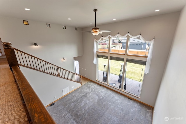 unfurnished living room featuring ceiling fan and light colored carpet