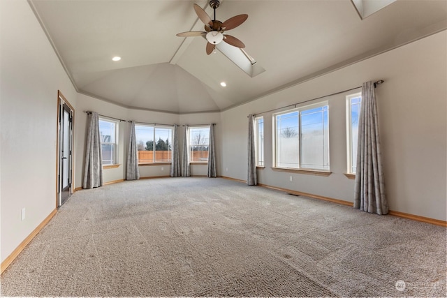 empty room with ceiling fan, light carpet, and lofted ceiling with skylight