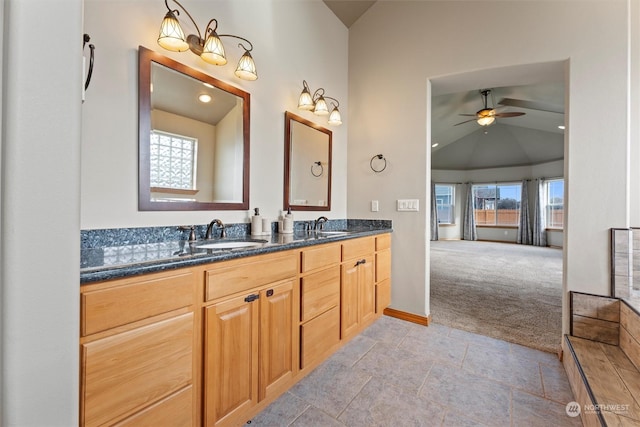 bathroom featuring vaulted ceiling, ceiling fan, a wealth of natural light, and vanity