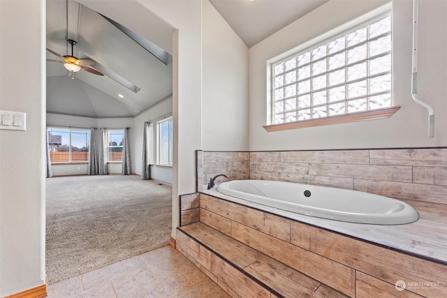 bathroom with ceiling fan, a relaxing tiled tub, and high vaulted ceiling