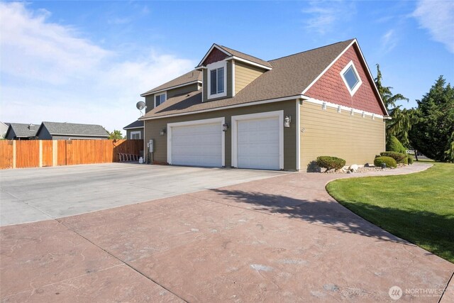 527 Rd I.6 NE, Moses Lake, WA 98837 - view of side of home with concrete driveway, roof with shingles, and an attached garage