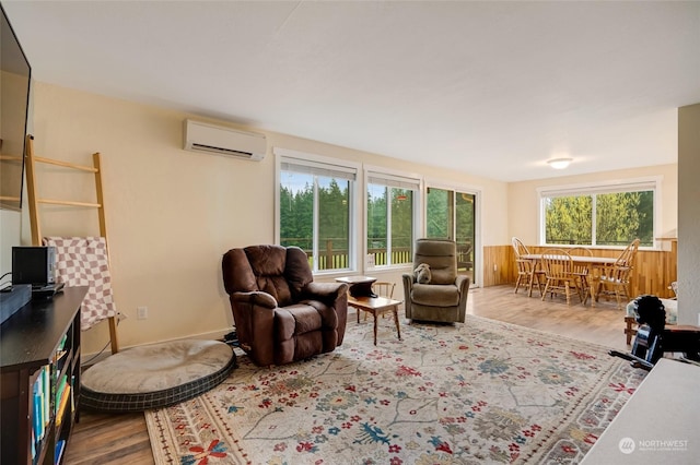 living room with a wall unit AC and hardwood / wood-style floors