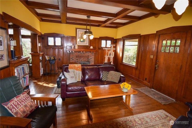 living room with coffered ceiling, dark hardwood / wood-style flooring, wood walls, and beamed ceiling