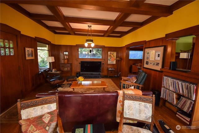 living room featuring coffered ceiling, wooden walls, beamed ceiling, and ornate columns