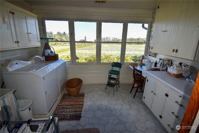 washroom featuring washing machine and dryer, cabinets, and tile patterned floors