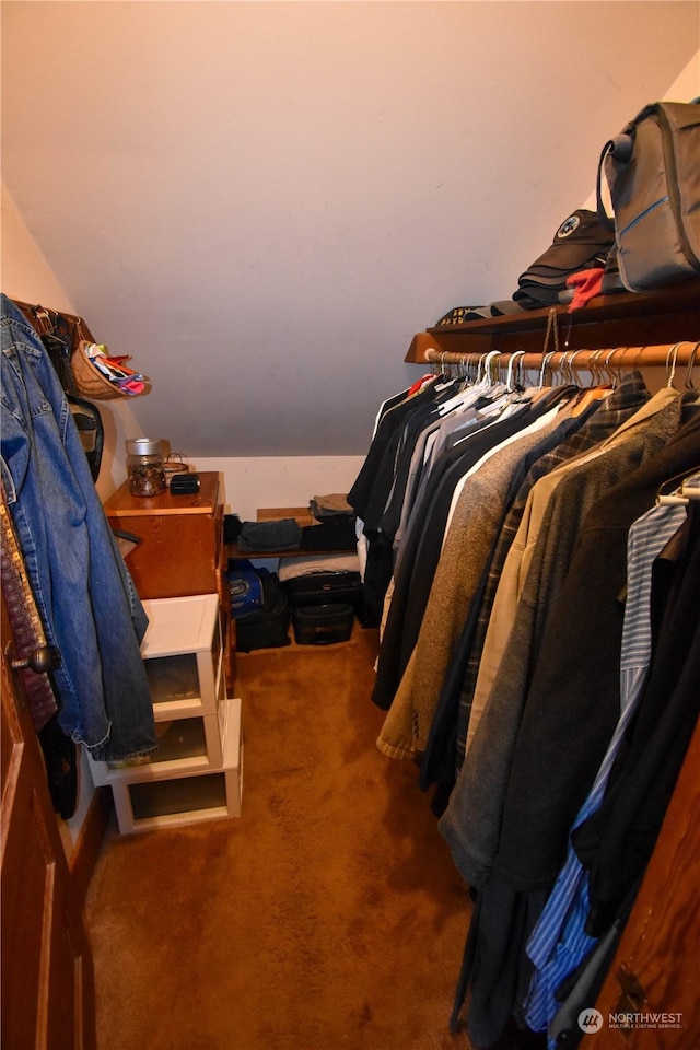 walk in closet with lofted ceiling and dark carpet