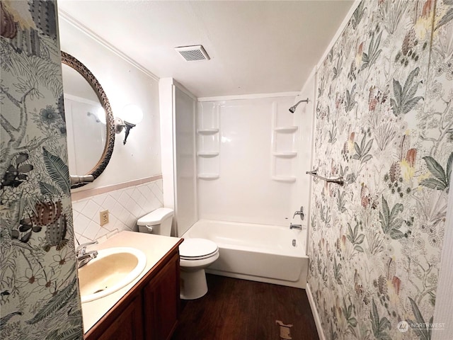 full bathroom with toilet, tile walls, crown molding, wood-type flooring, and vanity