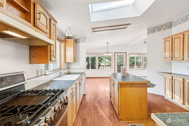 kitchen featuring light hardwood / wood-style flooring, sink, stainless steel gas range oven, and a kitchen island