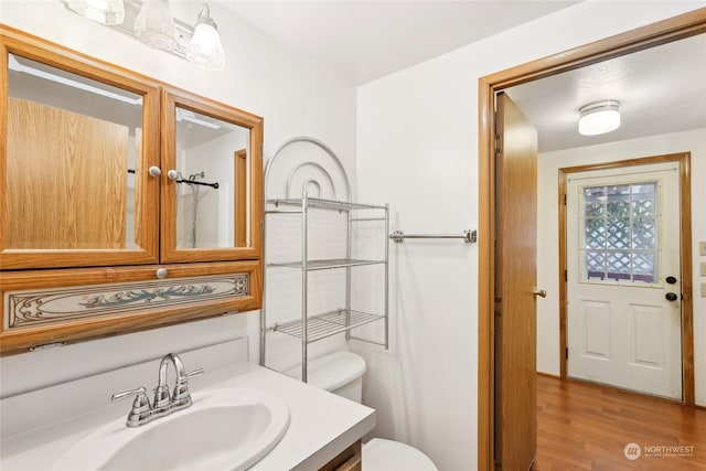 bathroom featuring hardwood / wood-style flooring, vanity, and toilet