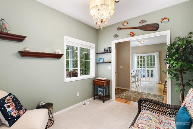 sitting room featuring lofted ceiling, carpet floors, and a chandelier