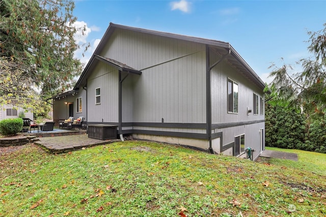 view of side of home featuring a yard and a patio area