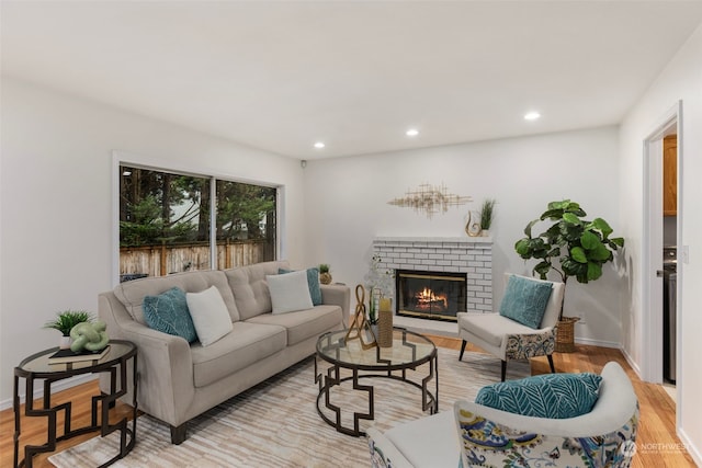 living room featuring light hardwood / wood-style floors and a brick fireplace