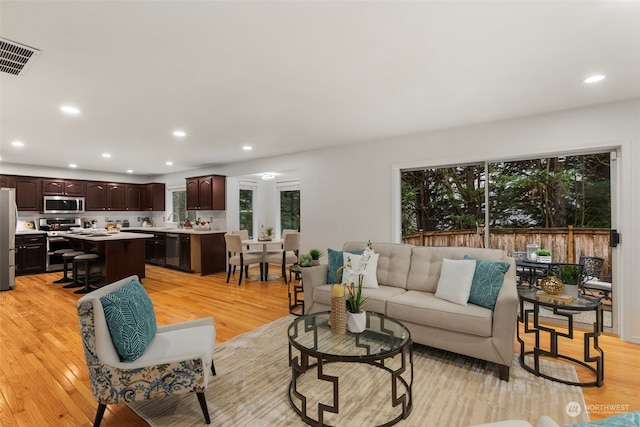 living room with sink and light hardwood / wood-style flooring