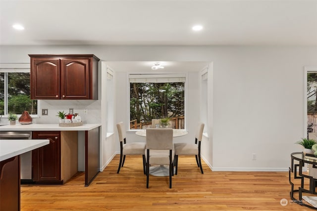 kitchen with dishwasher, light hardwood / wood-style floors, dark brown cabinets, and decorative backsplash