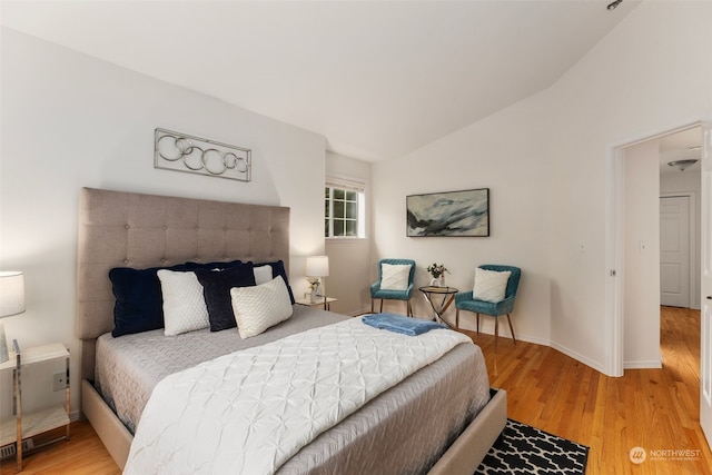 bedroom featuring light hardwood / wood-style flooring and lofted ceiling