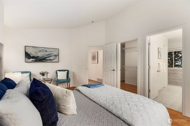 bedroom with a closet, a spacious closet, and hardwood / wood-style floors