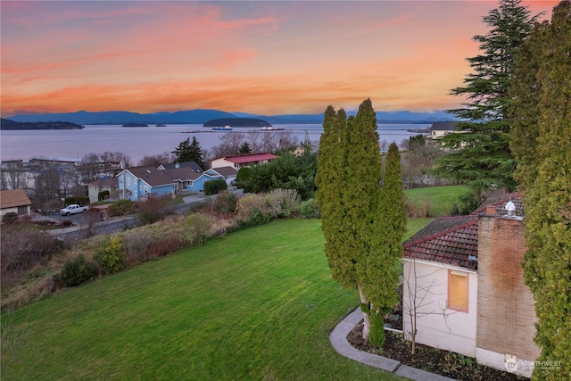 yard at dusk with a water and mountain view