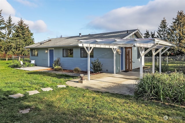 back of house with a patio and a lawn