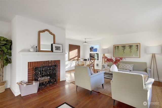 living room featuring dark wood-type flooring and a brick fireplace