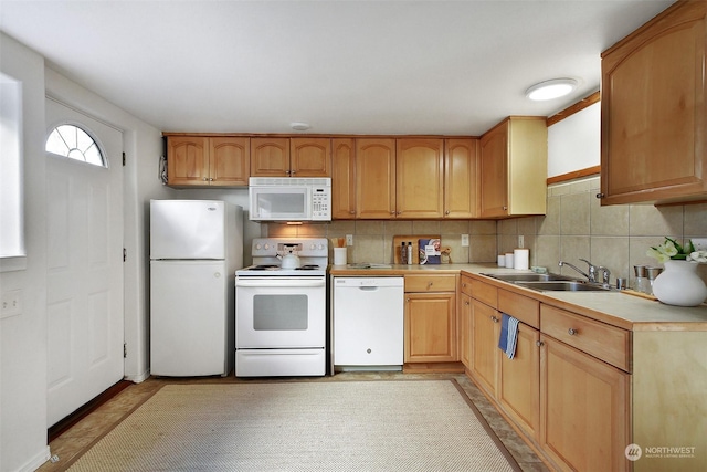 kitchen featuring white appliances, decorative backsplash, and sink