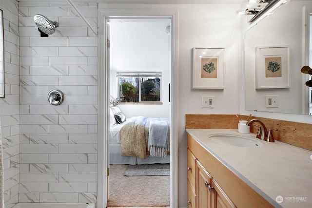 bathroom featuring tiled shower and vanity