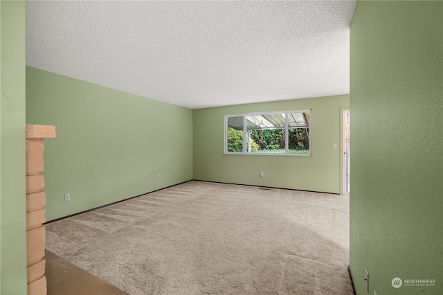 empty room featuring light carpet and a textured ceiling