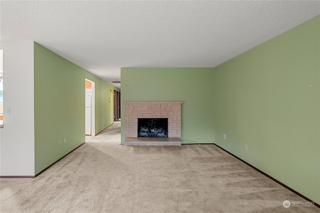 unfurnished living room with light carpet, a fireplace, and a textured ceiling