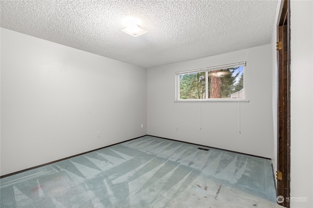 carpeted spare room with a textured ceiling