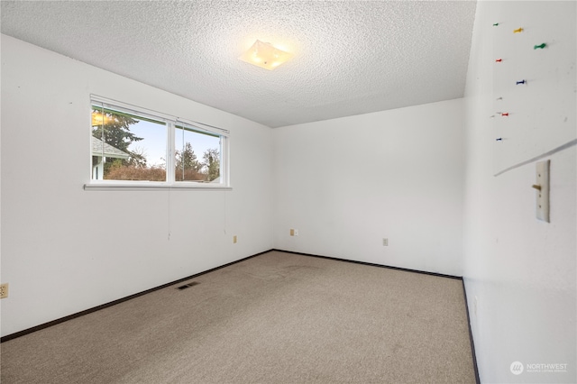 carpeted spare room featuring a textured ceiling