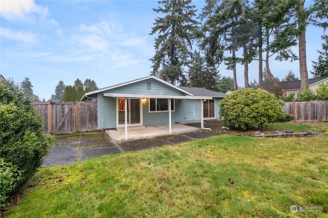 back of property with a patio area and a lawn