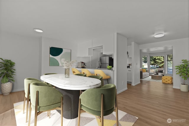 dining room featuring sink and light hardwood / wood-style flooring