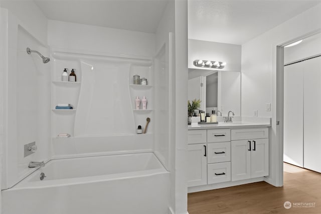 bathroom with wood-type flooring, shower / bathing tub combination, and vanity