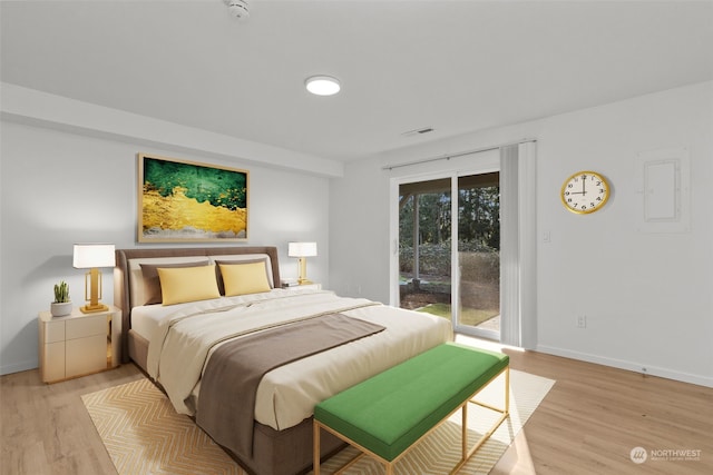 bedroom featuring electric panel, access to outside, and light wood-type flooring