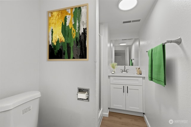 bathroom with vanity, toilet, and wood-type flooring