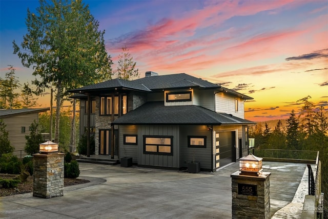 back house at dusk with a garage