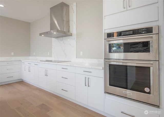 kitchen featuring stainless steel double oven, range hood, black electric stovetop, and white cabinetry