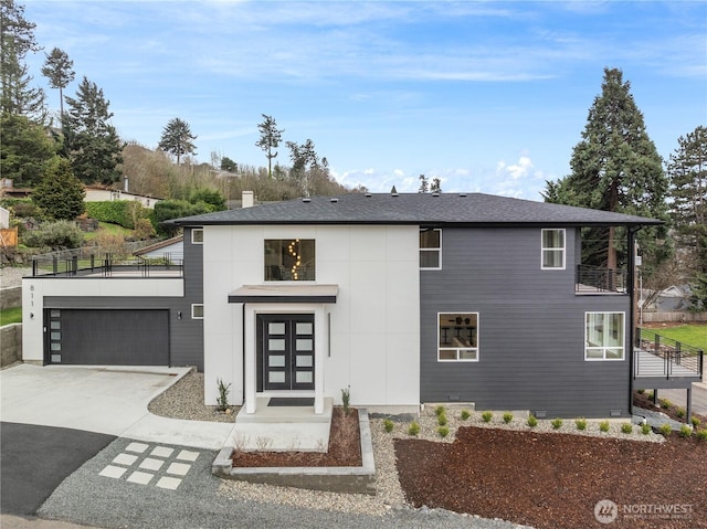 view of front of property with a garage, driveway, a shingled roof, and a balcony