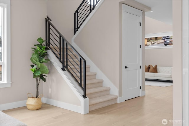 stairway with wood finished floors and baseboards