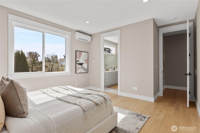 bedroom with multiple windows, baseboards, light wood-style floors, and a wall unit AC