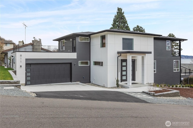 view of front of property featuring aphalt driveway and a balcony