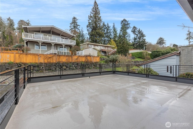 view of patio featuring a fenced front yard and a balcony