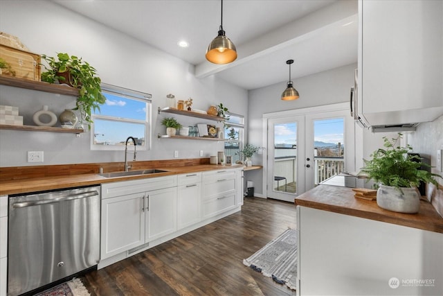 kitchen featuring pendant lighting, wood counters, white cabinetry, sink, and stainless steel dishwasher