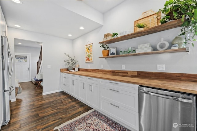 kitchen with white cabinets, dark hardwood / wood-style flooring, butcher block counters, and stainless steel appliances