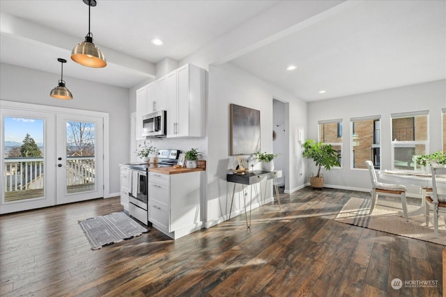 kitchen with white cabinets, appliances with stainless steel finishes, wood counters, decorative light fixtures, and french doors