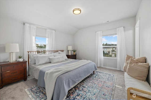 carpeted bedroom with multiple windows and vaulted ceiling